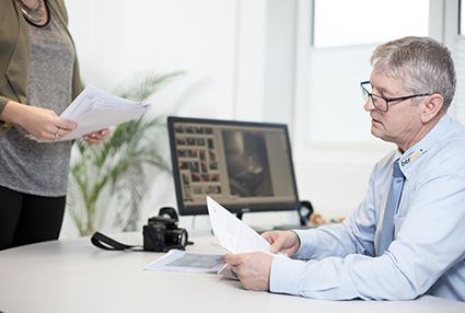 Experte prüft Unterlagen für eine Kfz Kaufberatung
